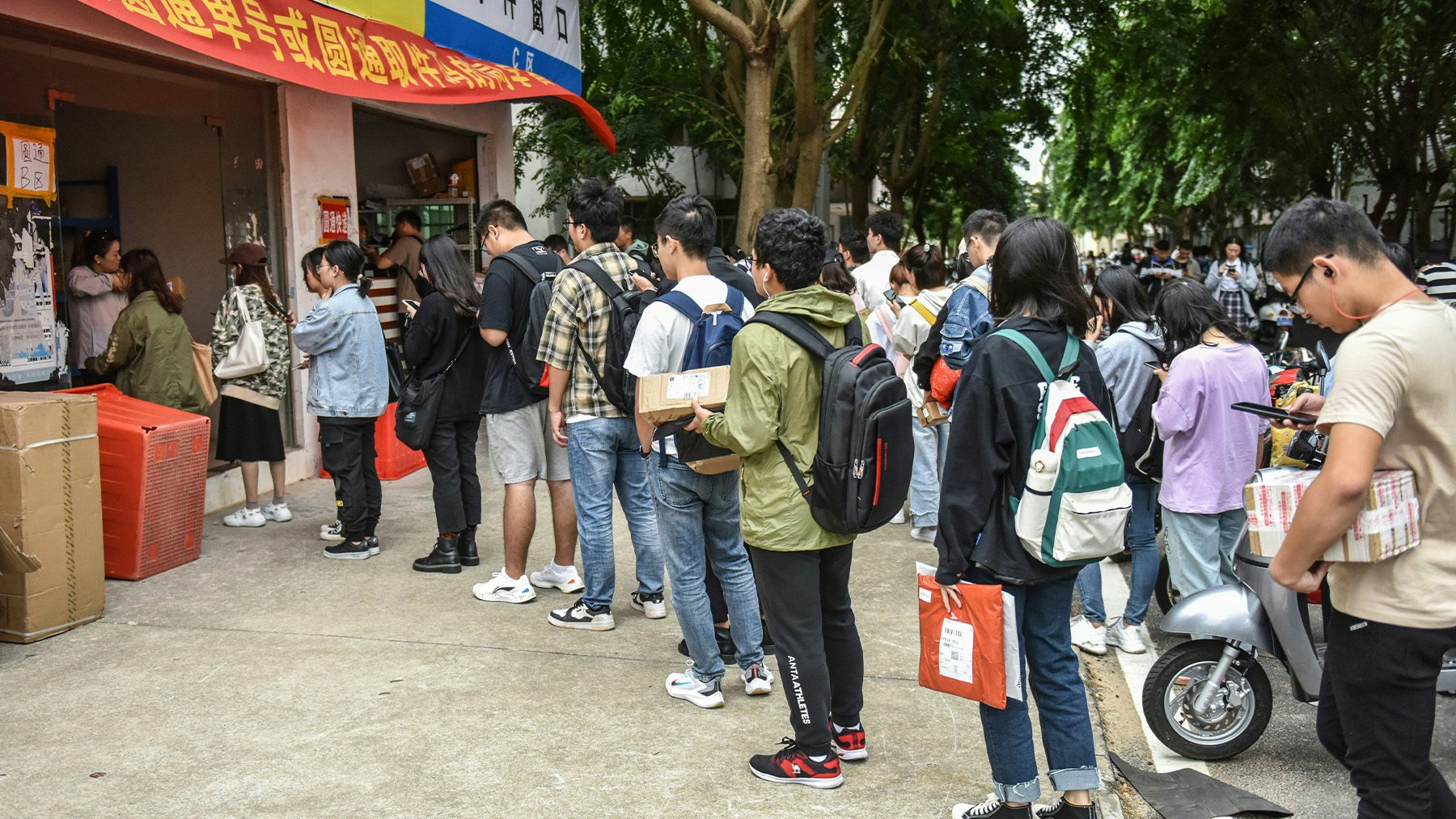 College students queue to pick up packages at an online shopping pick up point during a shopping festival. Getty Images.