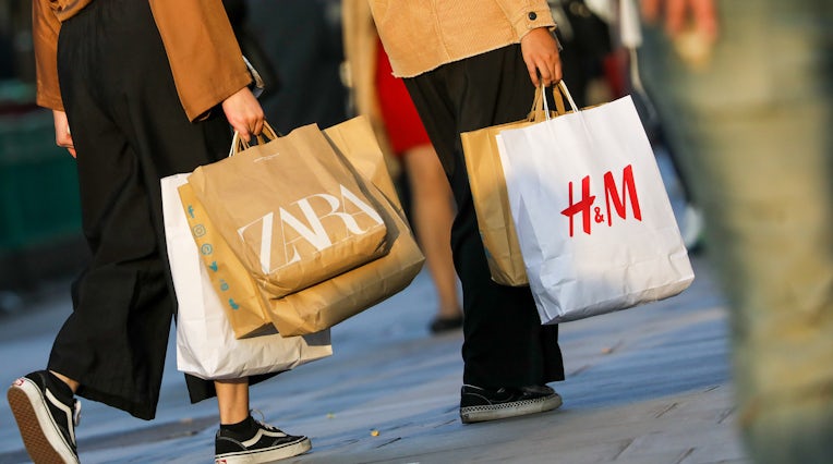 购物者在英国伦敦携带Zara和H＆M包。 盖蒂图片社。