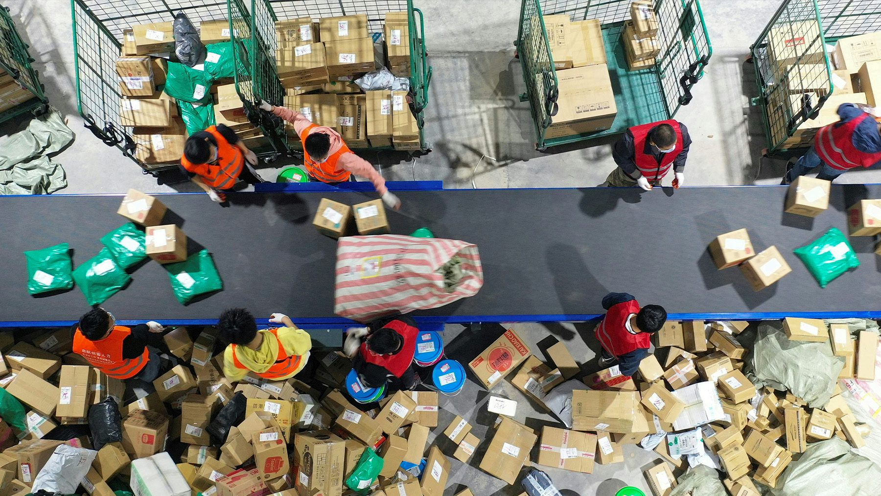 Workers sort packages for delivery at a warehouse of China Post Group in Hengyang, Hunan province. Getty Images.